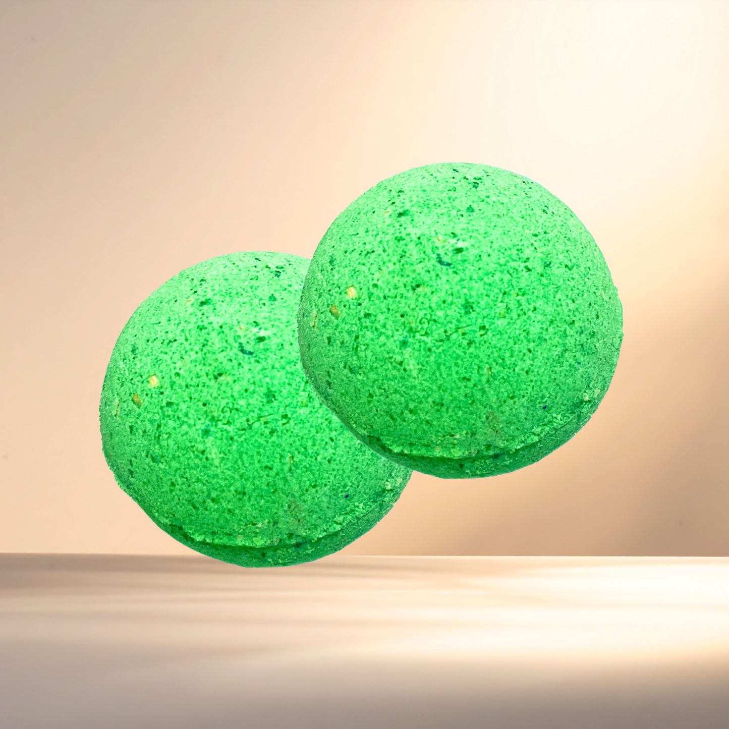 Two green bath bombs on a beige background
