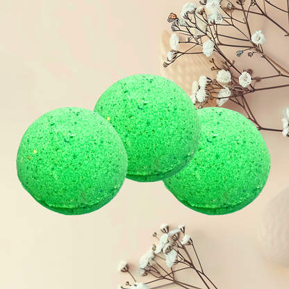 Three green bath bombs with white flowers on a beige background
