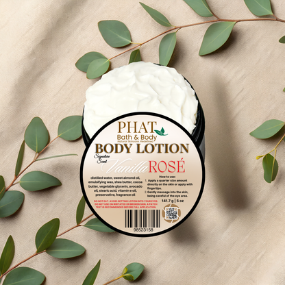 Body lotion container labeled 'PHAT Bath & Body' with 'Vanilla Rosé' on a beige fabric background with green leaves.