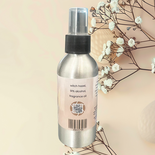 Bottle of fragrance spray on a beige background with white flowers.