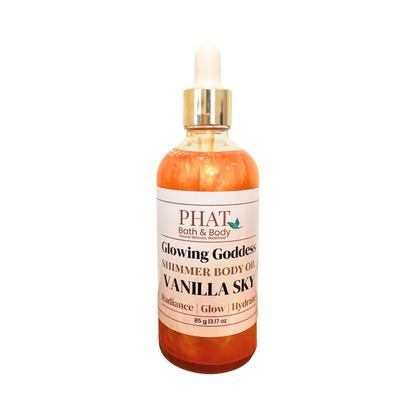 PHAT Bath & Body 'Glowing Goddess' shimmer body oil in a clear bottle with a white dropper cap and gold collar, labeled 'Vanilla Sky' with orange-amber liquid inside, on a white background.