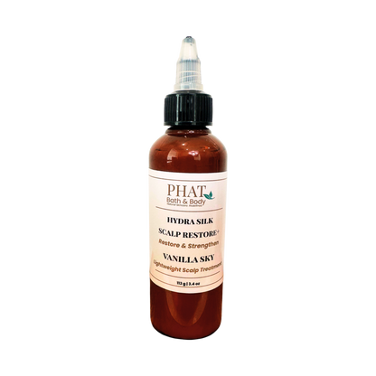 A bottle of PHAT Bath & Body Hydra Silk Scalp Restore in Vanilla Sky scent, featuring an amber bottle, black dropper cap, and a cream-colored label.