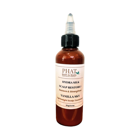 A bottle of PHAT Bath & Body Hydra Silk Scalp Restore in Vanilla Sky scent, featuring an amber bottle, black dropper cap, and a cream-colored label.