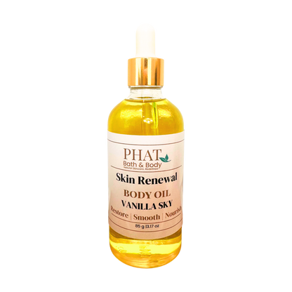 A bottle of PHAT Bath & Body Skin Renewal Body Oil in Vanilla Sky scent, filled with golden yellow oil and featuring a white label with a gold cap, set against a plain white background.
