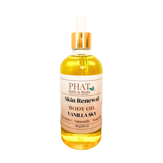A bottle of PHAT Bath & Body Skin Renewal Body Oil in Vanilla Sky scent, filled with golden yellow oil and featuring a white label with a gold cap, set against a plain white background.