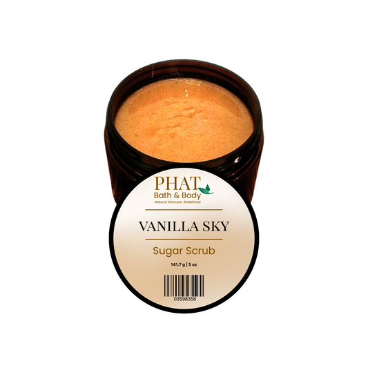 An open dark amber jar of PHAT Bath & Body Vanilla Sky Sugar Scrub, showing the light brown scrub inside, with a white circular label in front on a plain white background.