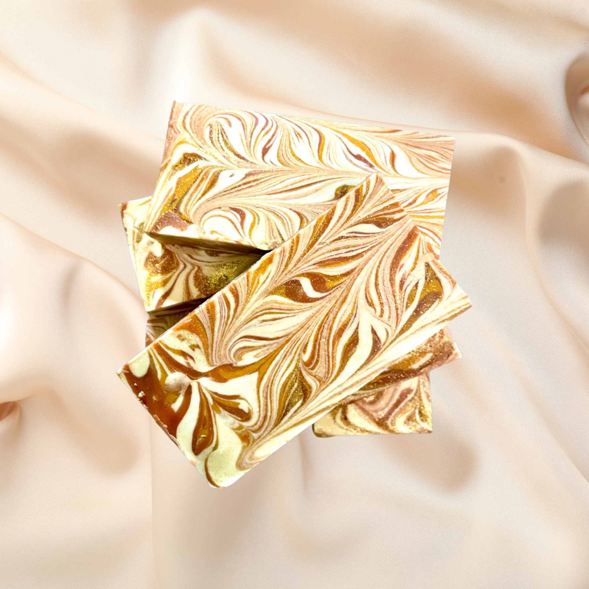 Marbled gold and bronze soap bar on a soft pink fabric background