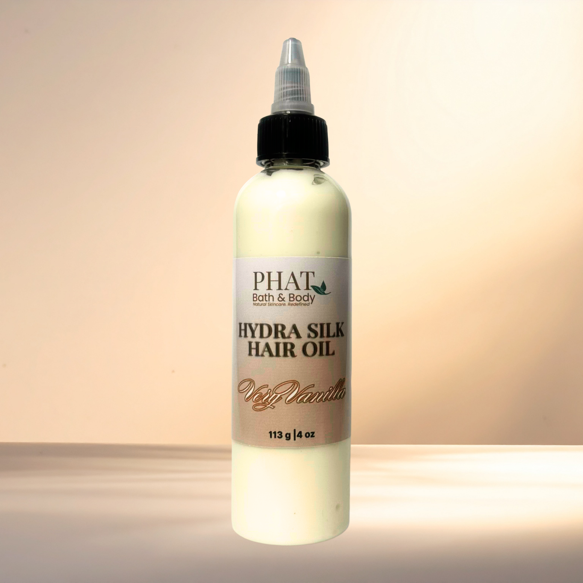 Bottle of PHAT Bath & Body Hydra Silk Hair Oil on a gradient background