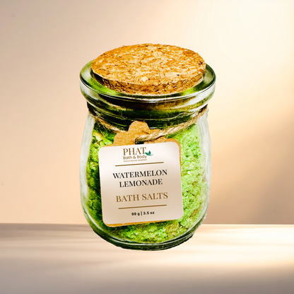 Jar of watermelon lemonade bath salts with a cork lid on a neutral background