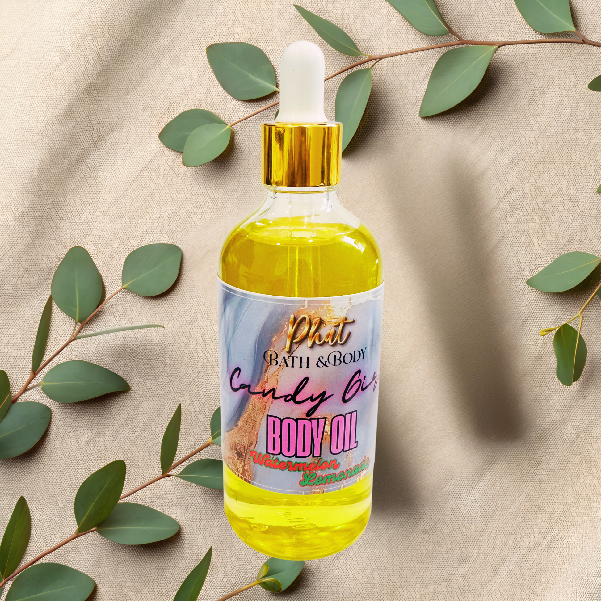 Body oil bottle with a colorful label on a beige fabric background with green leaves.