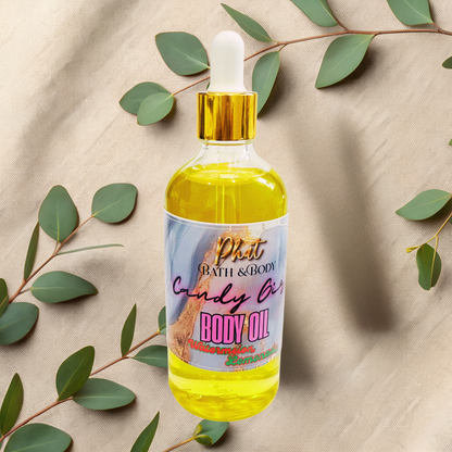 Body oil bottle with a colorful label on a beige fabric background with green leaves.