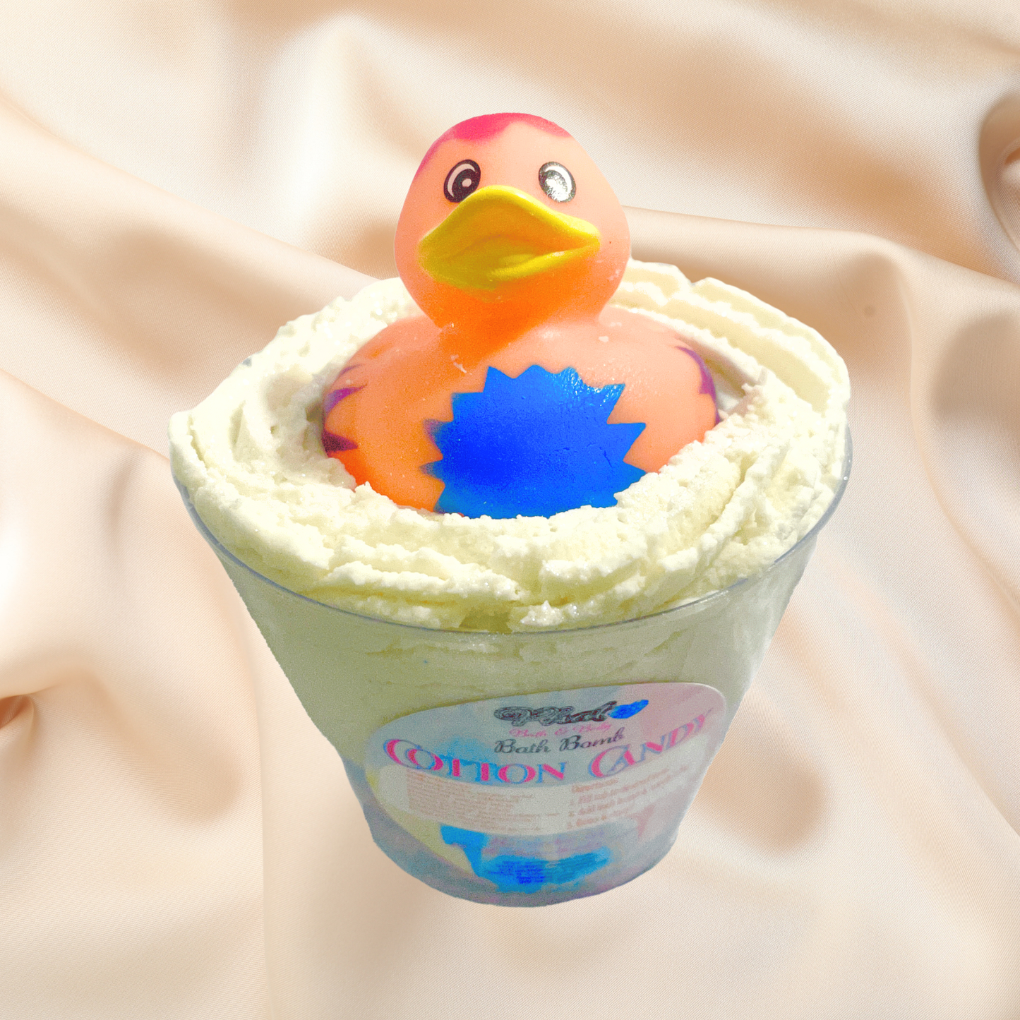 Rubber duck toy in a bubble bomb labeled 'Cotton Candy' on a soft beige background