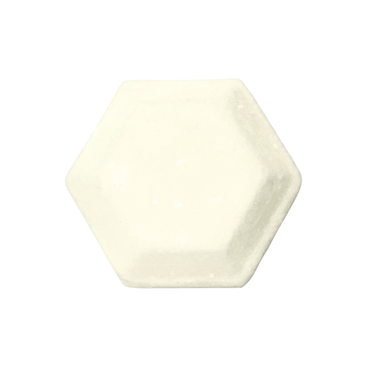 Hexagonal shower steamer in a plain cream color on a white background