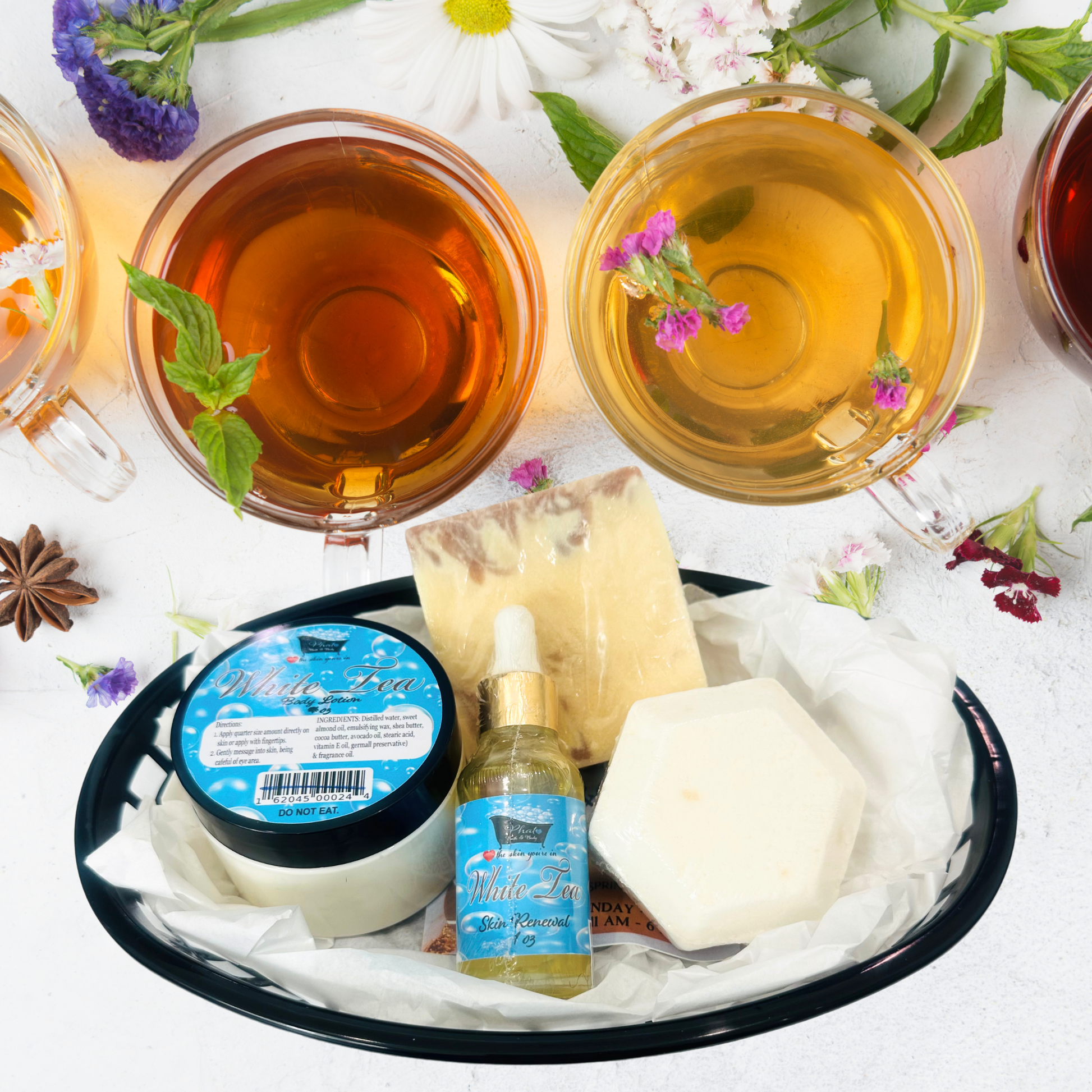 Soap, and cream on a white surface with flowers and leaves.