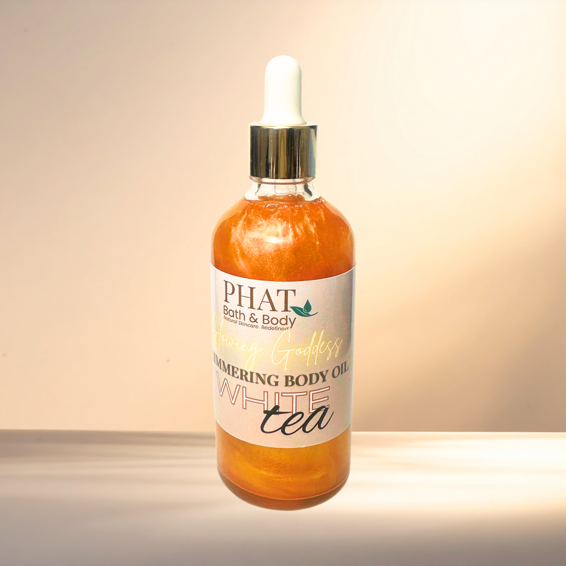 Bottle of PHAT Bath & Body White Tea body oil on a neutral background