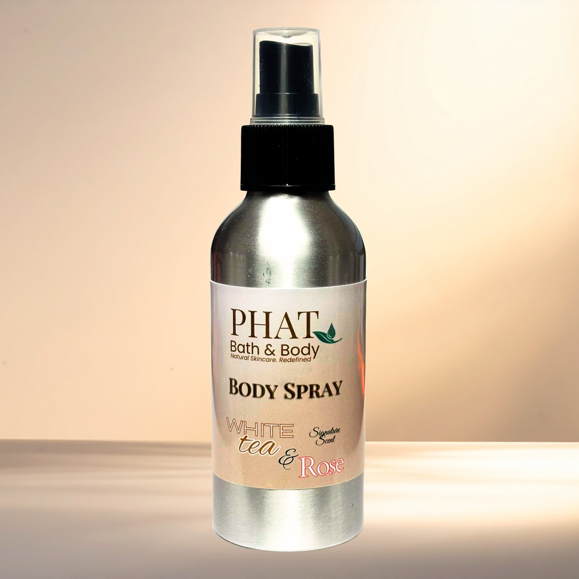 Body spray bottle labeled 'PHAT Bath & Body' with a white tea and rose scent on a gradient background.