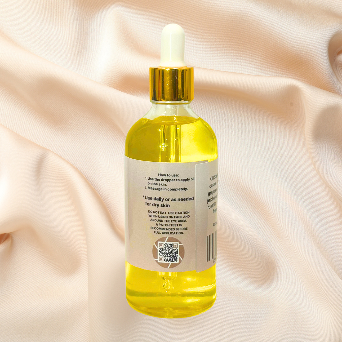 Bottle of yellow liquid with dropper on a beige fabric background