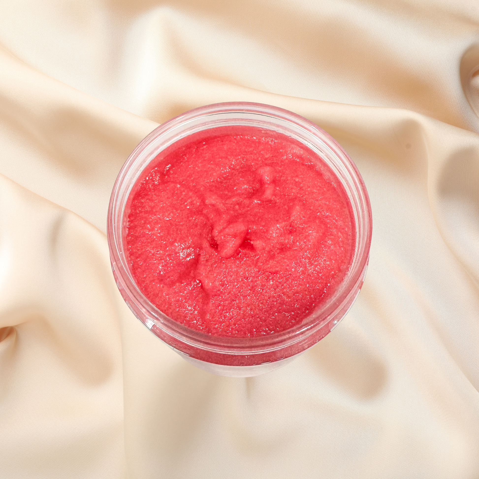 Pink sugar scrub in a jar on beige fabric
