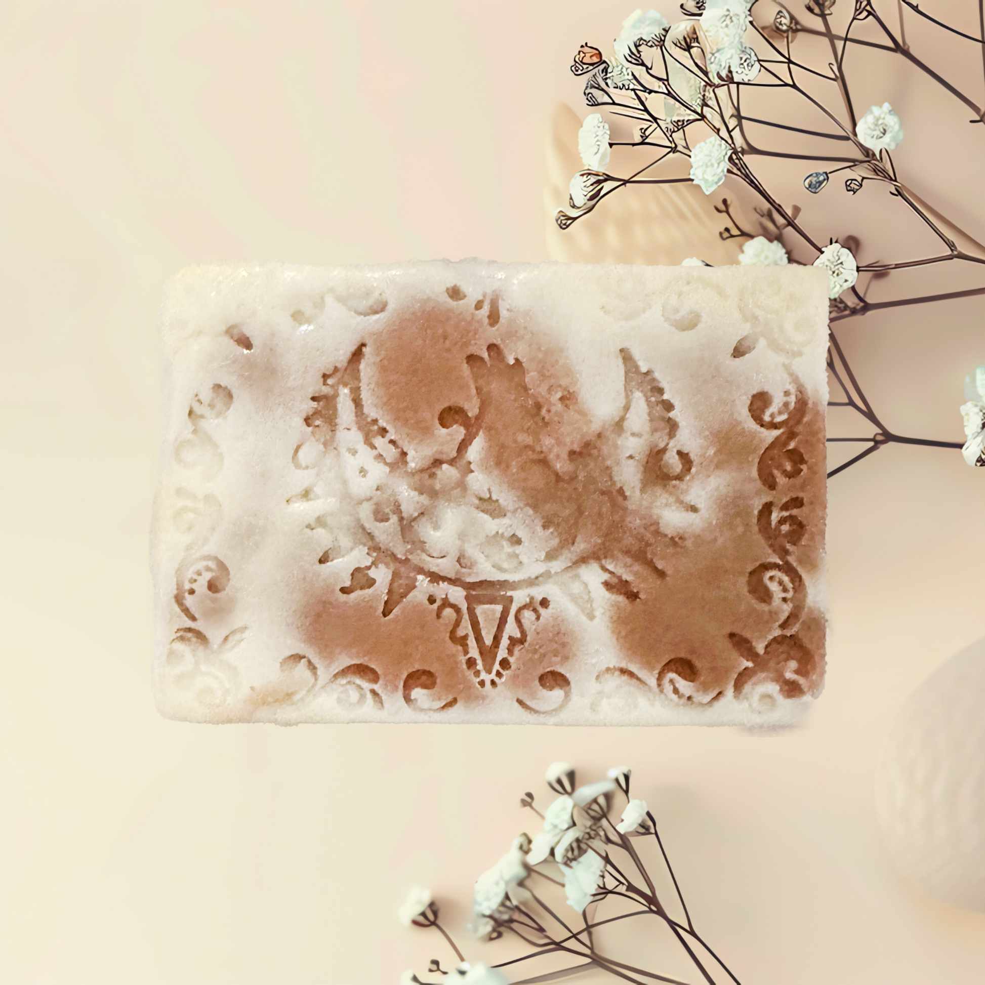 Decorative soap bar with intricate designs on a light background with flowers.