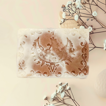 Decorative soap bar with intricate designs on a light background with flowers.