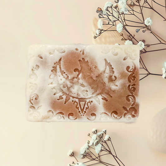 Decorative soap bar with intricate designs on a light background with flowers.