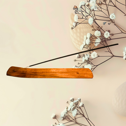 Wooden incense stick holder with white flowers on a beige background