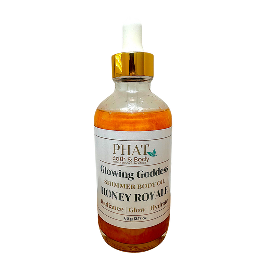 Phat Bath & Body Honey Royale shimmering body oil in a glass bottle with a gold cap for radiant hydrated skin