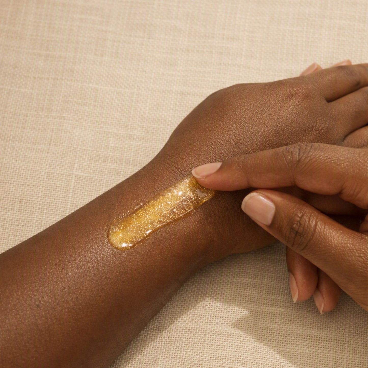 Golden shimmer body oil swatch showing the luminous finish on skin.