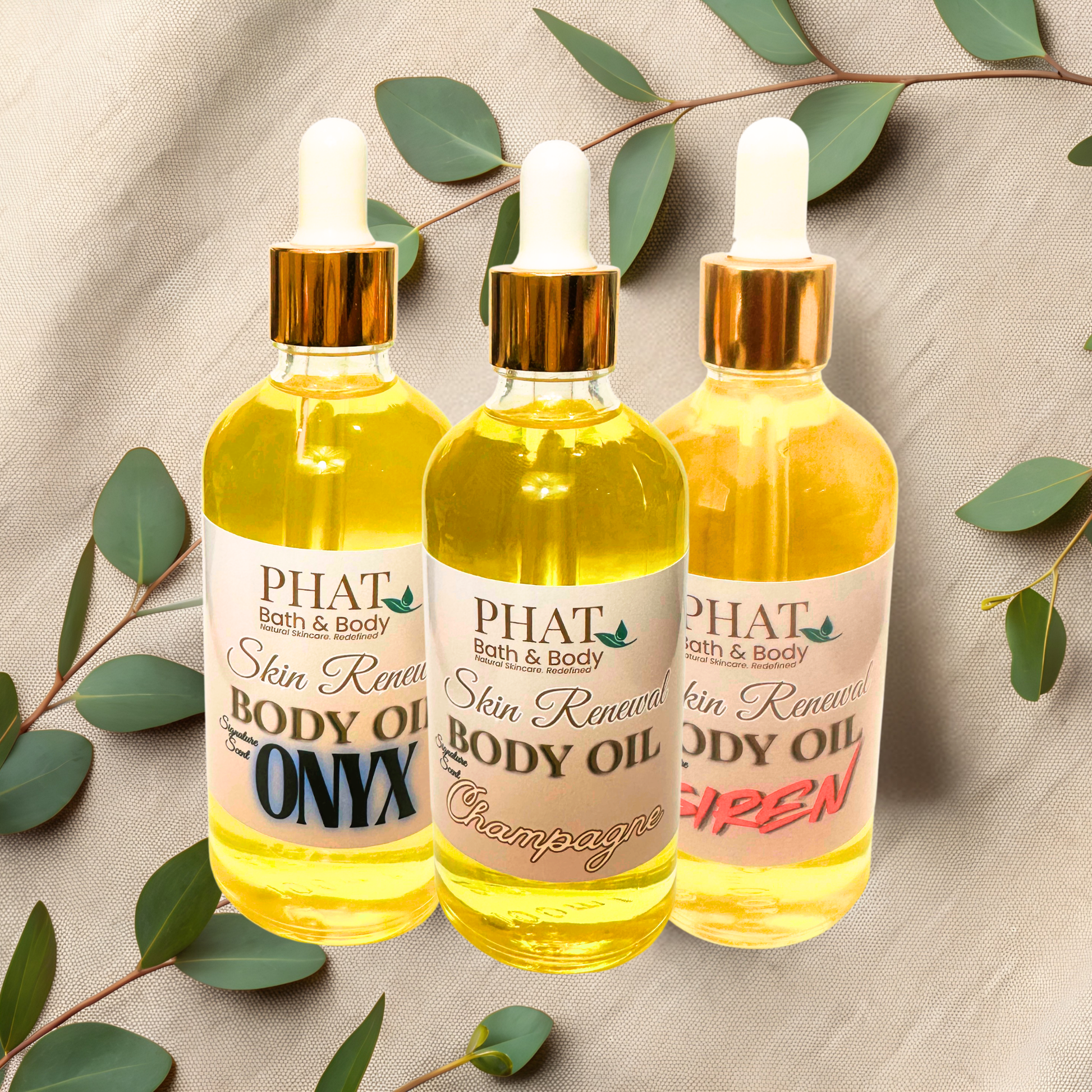 Three bottles of 'Phat Bath & Body' skin renewal body oil with green leaves on a beige background.